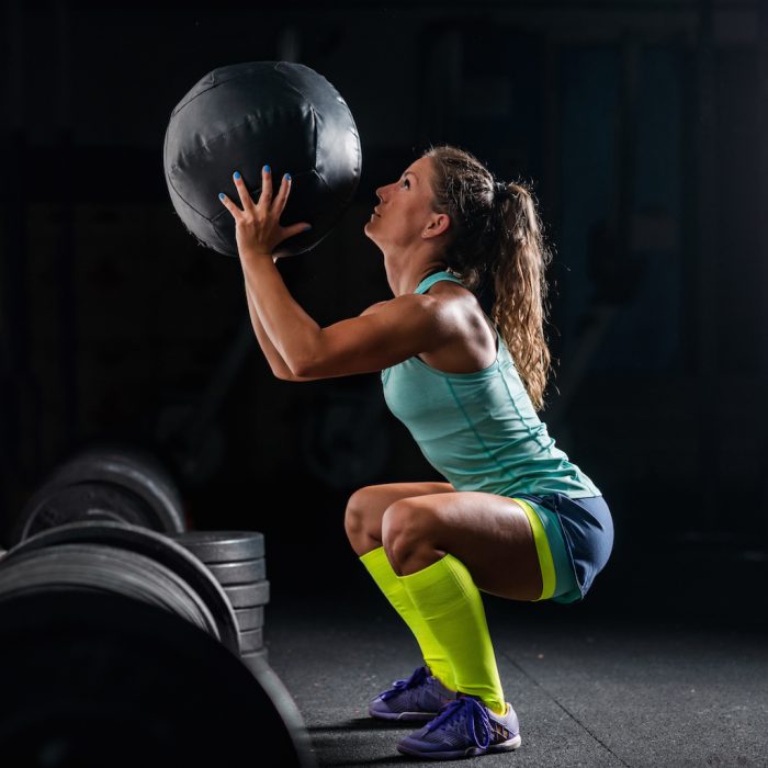 woman-athlete-exercising-with-medicine-ball-PYB74ZY